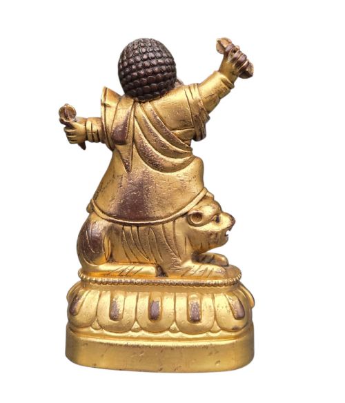 fig 2. A sixteenth to seventeenth-century Sino-Tibetan gilt-bronze votive figure depicting a wrathful deity seated on a tiger atop a lotus pedestal.