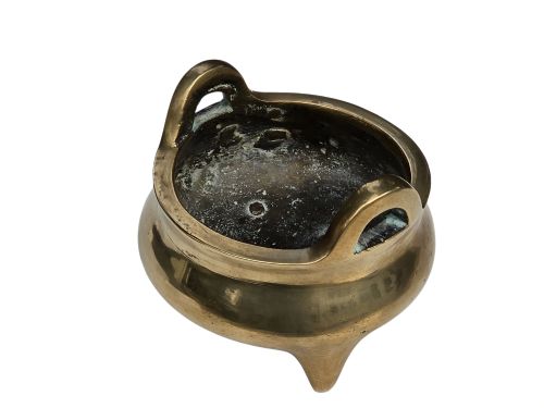 fig 2. A miniature cast bronze tripod censer featuring loop handles, conical legs, and natural surface patination.
