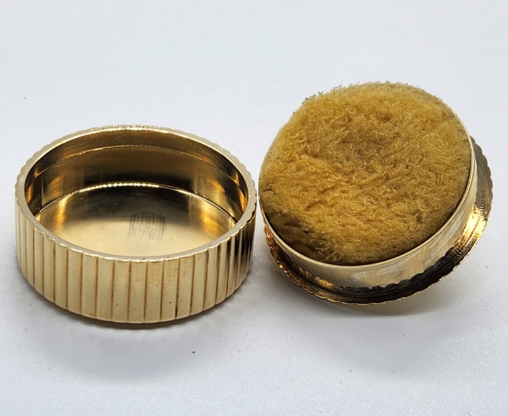 A circular polished yellow gold box featuring vertical fluted sides and a hinged semicircular handle with visible hallmarks. View II