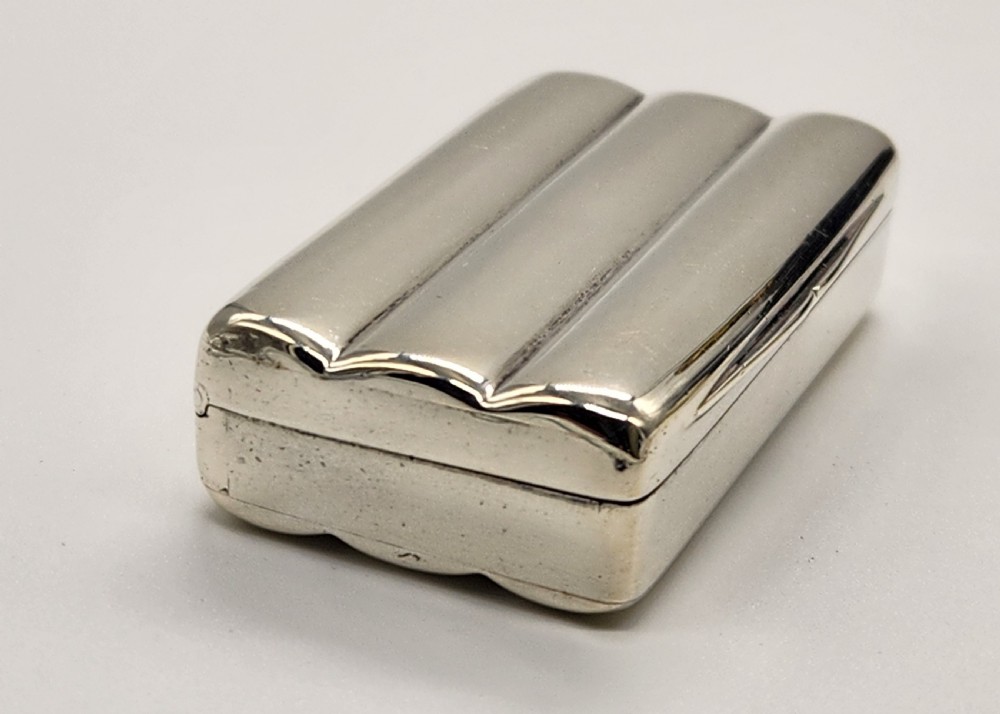 A small rectangular Georgian sterling silver snuff box featuring fluted channels on the cover and a polished silver finish. View V