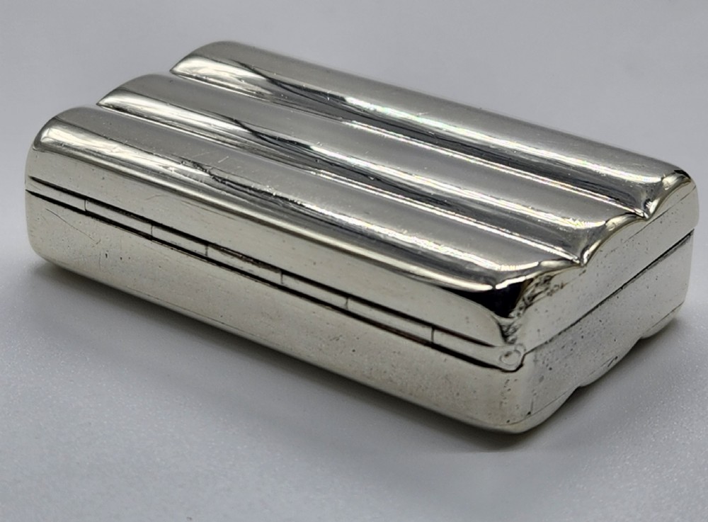 A small rectangular Georgian sterling silver snuff box featuring fluted channels on the cover and a polished silver finish. View IV