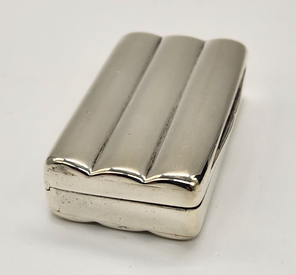 A small rectangular Georgian sterling silver snuff box featuring fluted channels on the cover and a polished silver finish. View IX