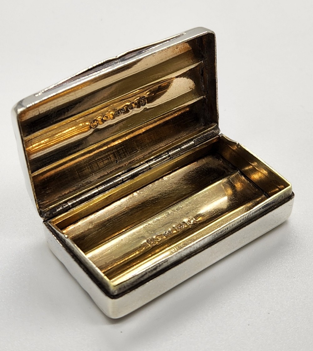 A small rectangular Georgian sterling silver snuff box featuring fluted channels on the cover and a polished silver finish. View X