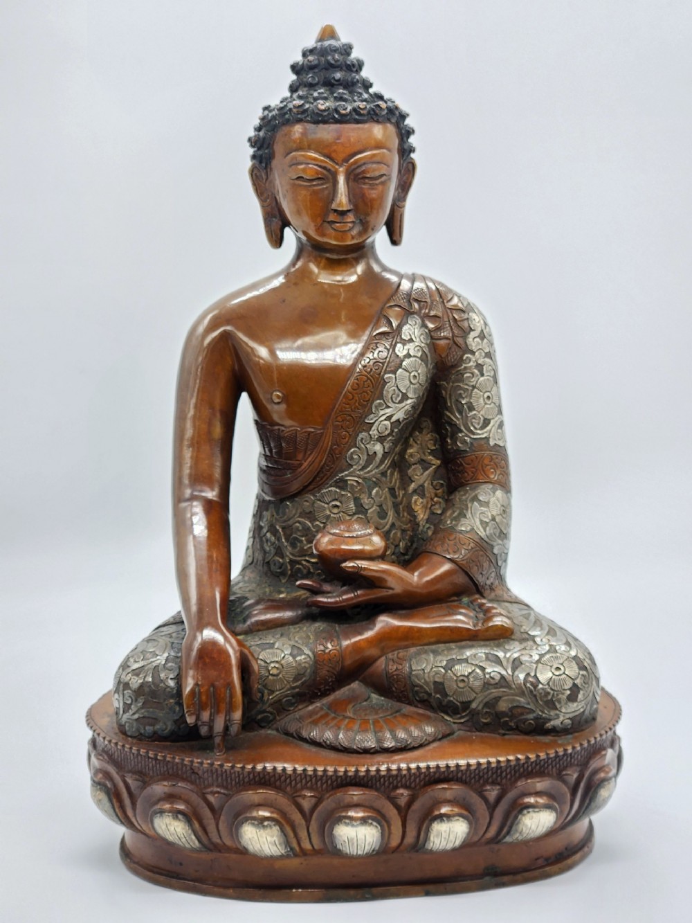 A LARGE SILVER-INLAID BRONZE FIGURE OF BUDDHA SHAKYAMUNI TIBET