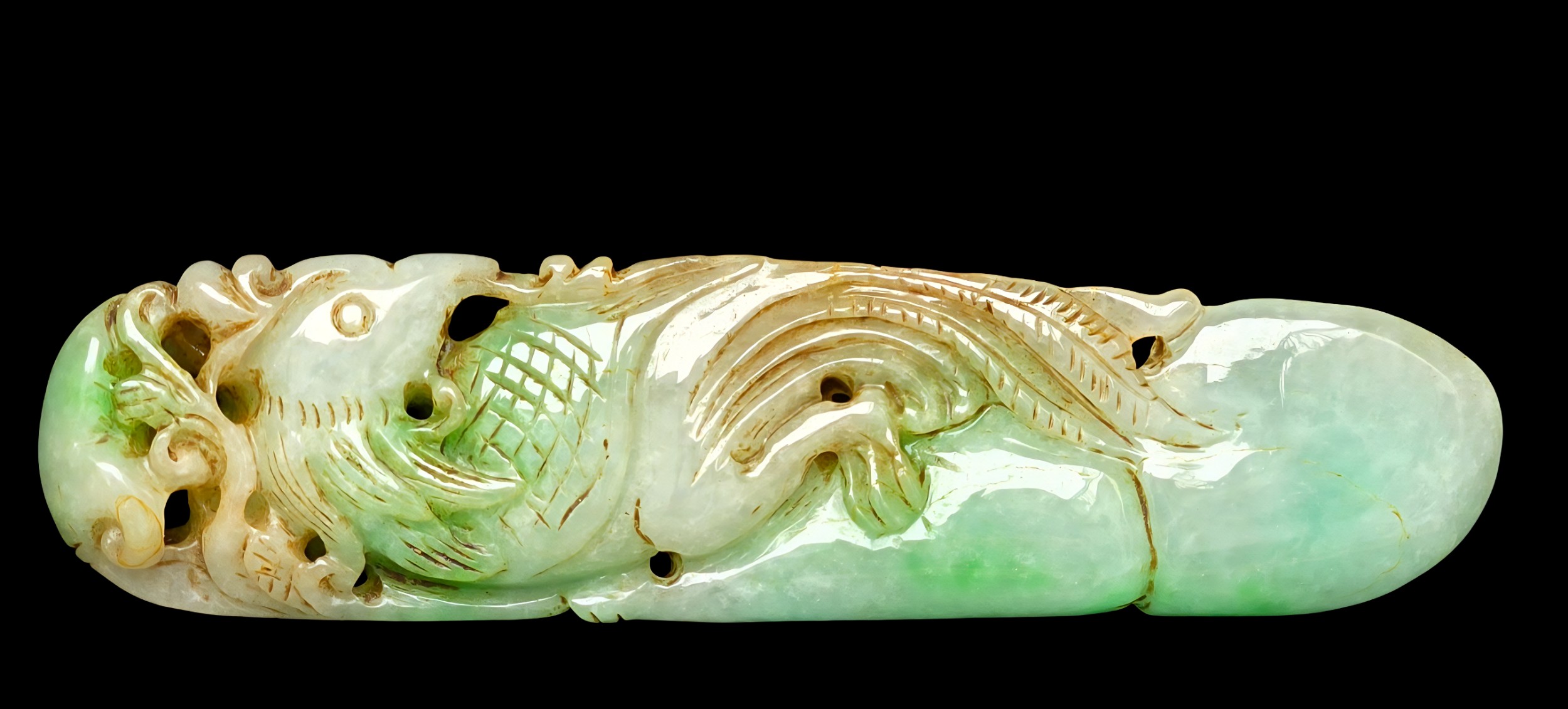A horizontal Chinese carved jade ornament featuring an aquatic motif with detailed scales, translucent green tones, and natural brown inclusions set against a black background.
