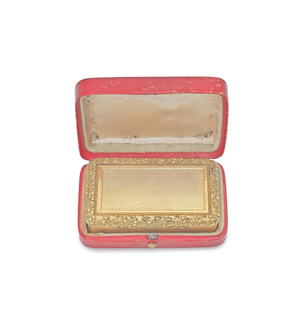 A rectangular 18 carat gold snuff box featuring engine-turned panels surrounded by a chased foliate border. View IV