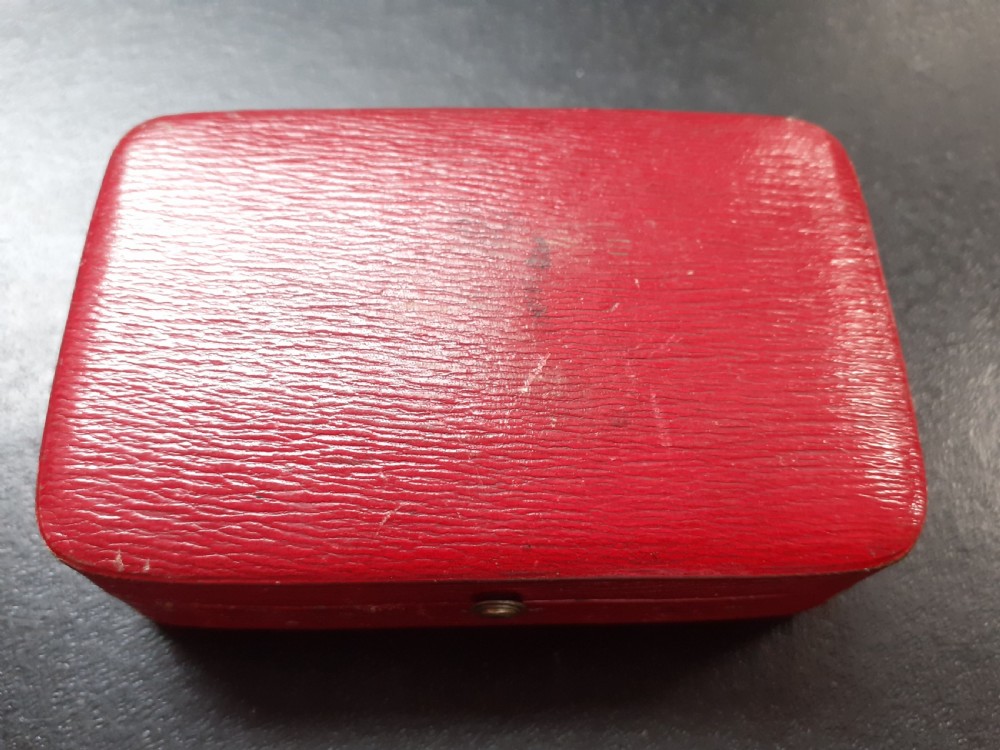 A rectangular 18 carat gold snuff box featuring engine-turned panels surrounded by a chased foliate border. View IX