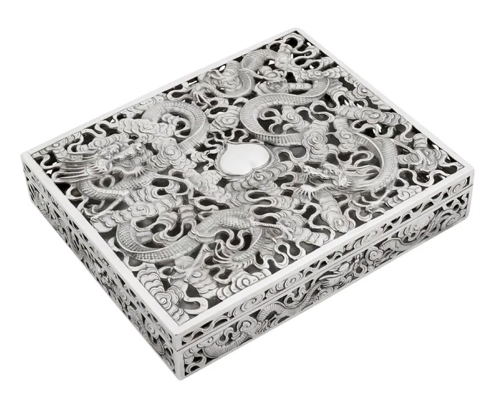 A rectangular silver box featuring detailed pierced openwork of two dragons amidst clouds around a central pearl. View III