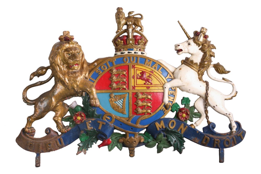A late Victorian polychrome painted cast iron British Royal Coat of Arms featuring a gilded lion and unicorn flanking a central crowned shield with heraldic mottos. View IV