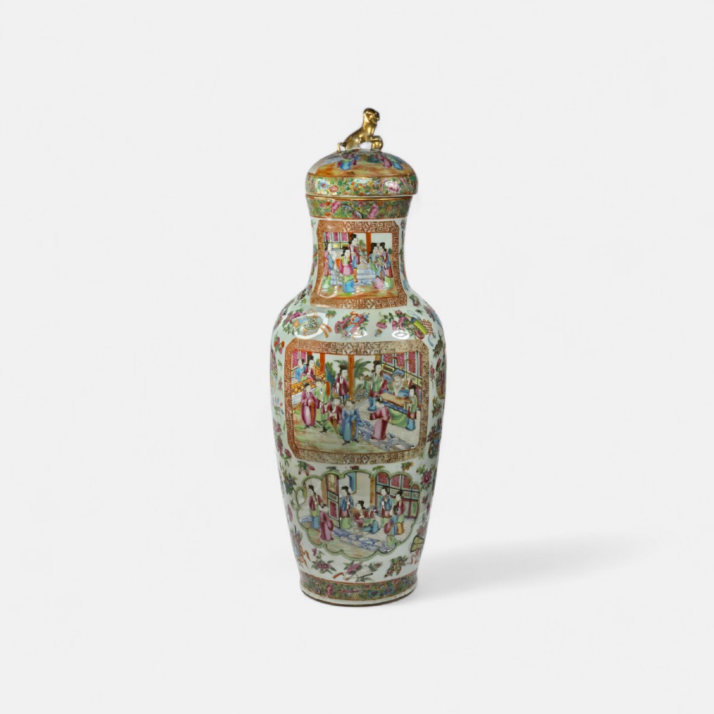 A 19th-century Cantonese Rose Mandarin porcelain baluster vase decorated with narrative figure panels, floral enamel borders, and a domed cover topped with a gilt foo dog finial.