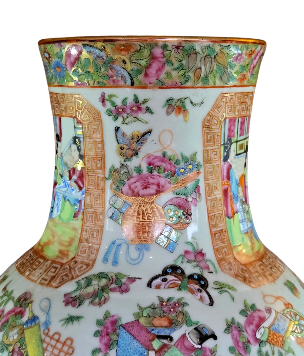 A 19th-century Cantonese Rose Mandarin porcelain baluster vase decorated with narrative figure panels, floral enamel borders, and a domed cover topped with a gilt foo dog finial. View V