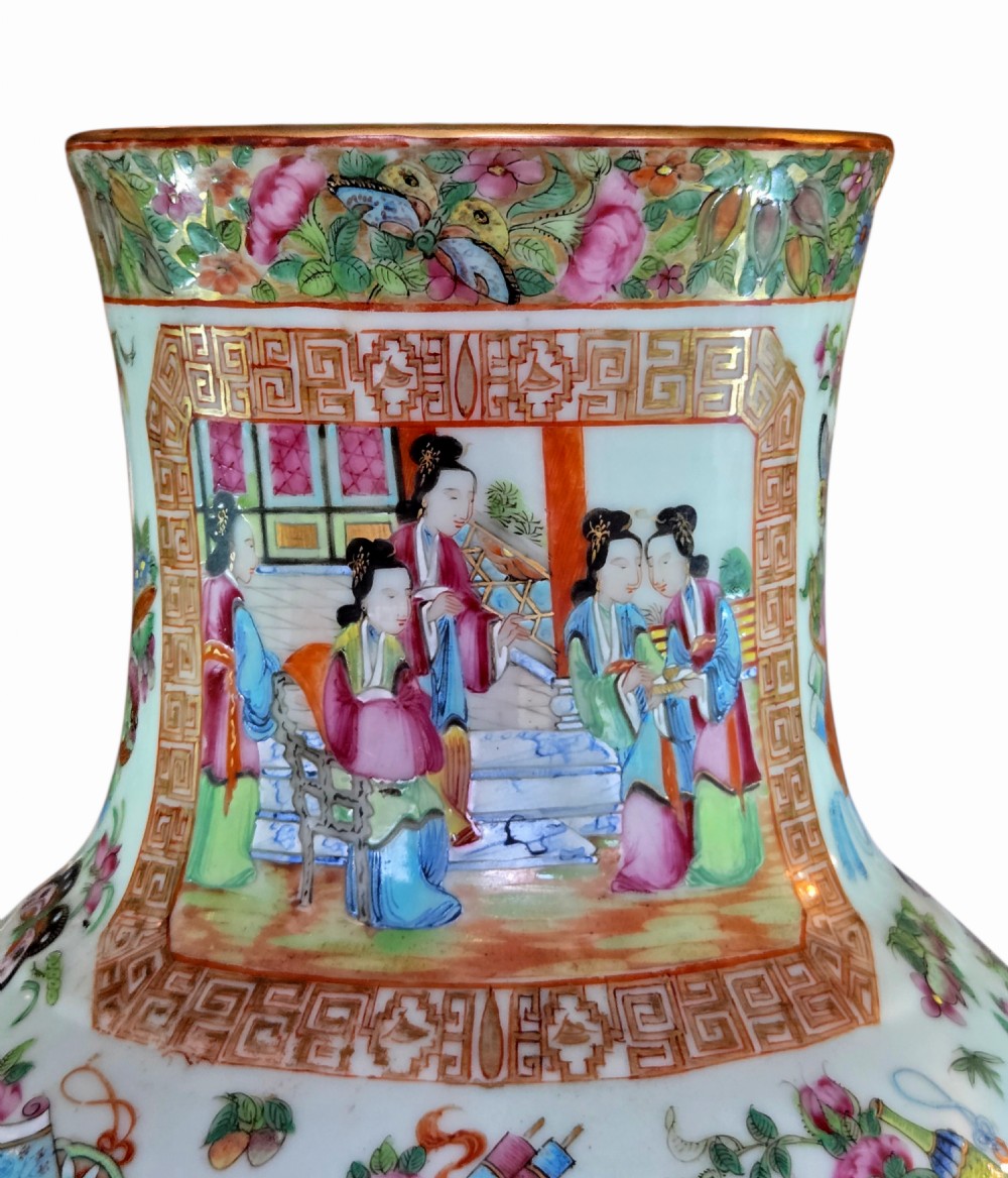 A 19th-century Cantonese Rose Mandarin porcelain baluster vase decorated with narrative figure panels, floral enamel borders, and a domed cover topped with a gilt foo dog finial. View VIII