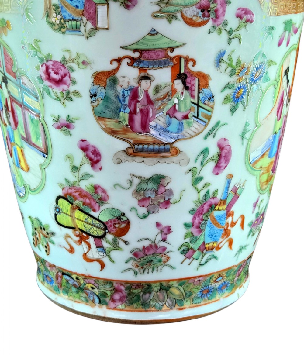 A 19th-century Cantonese Rose Mandarin porcelain baluster vase decorated with narrative figure panels, floral enamel borders, and a domed cover topped with a gilt foo dog finial. View IX