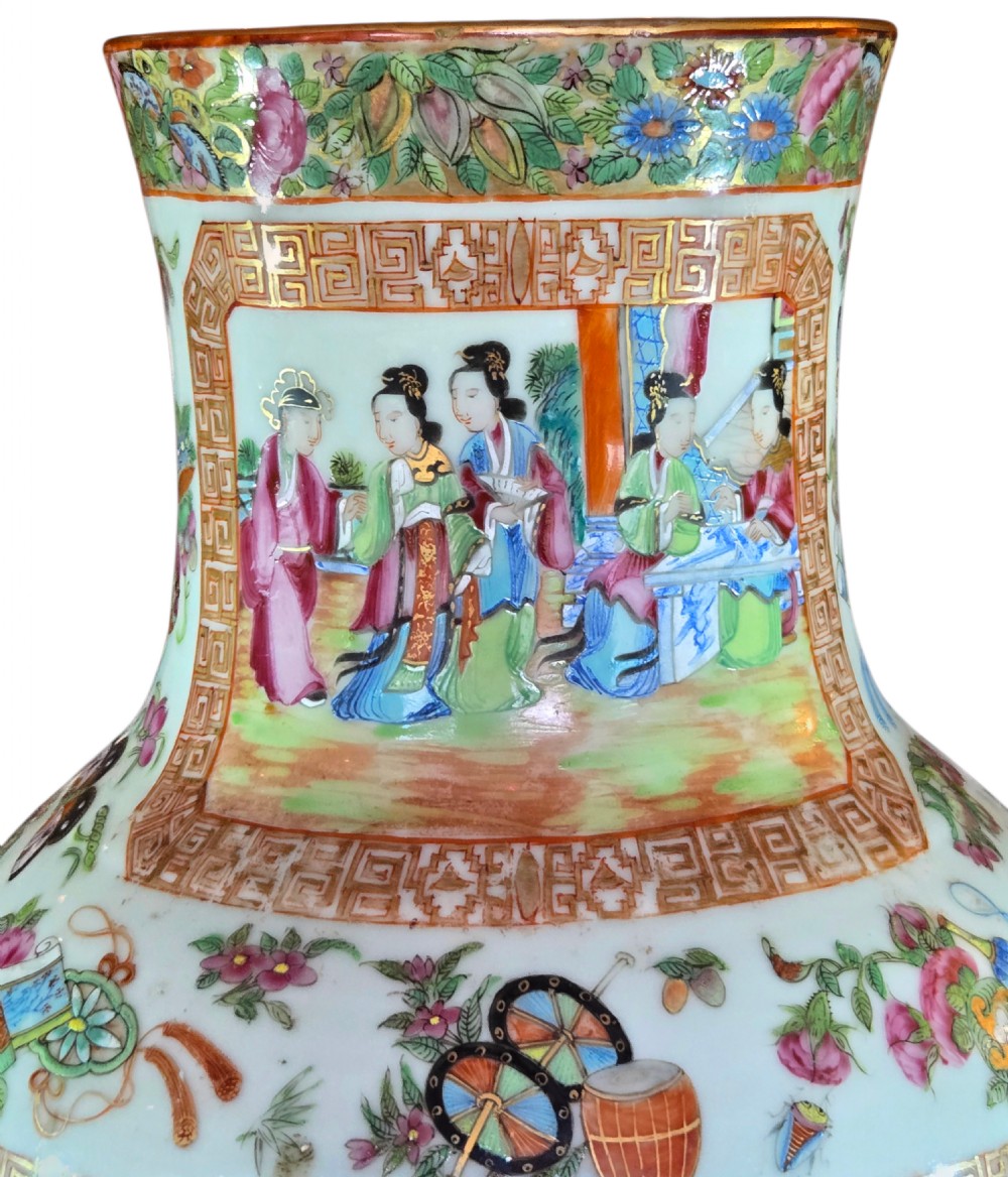 A 19th-century Cantonese Rose Mandarin porcelain baluster vase decorated with narrative figure panels, floral enamel borders, and a domed cover topped with a gilt foo dog finial. View XII