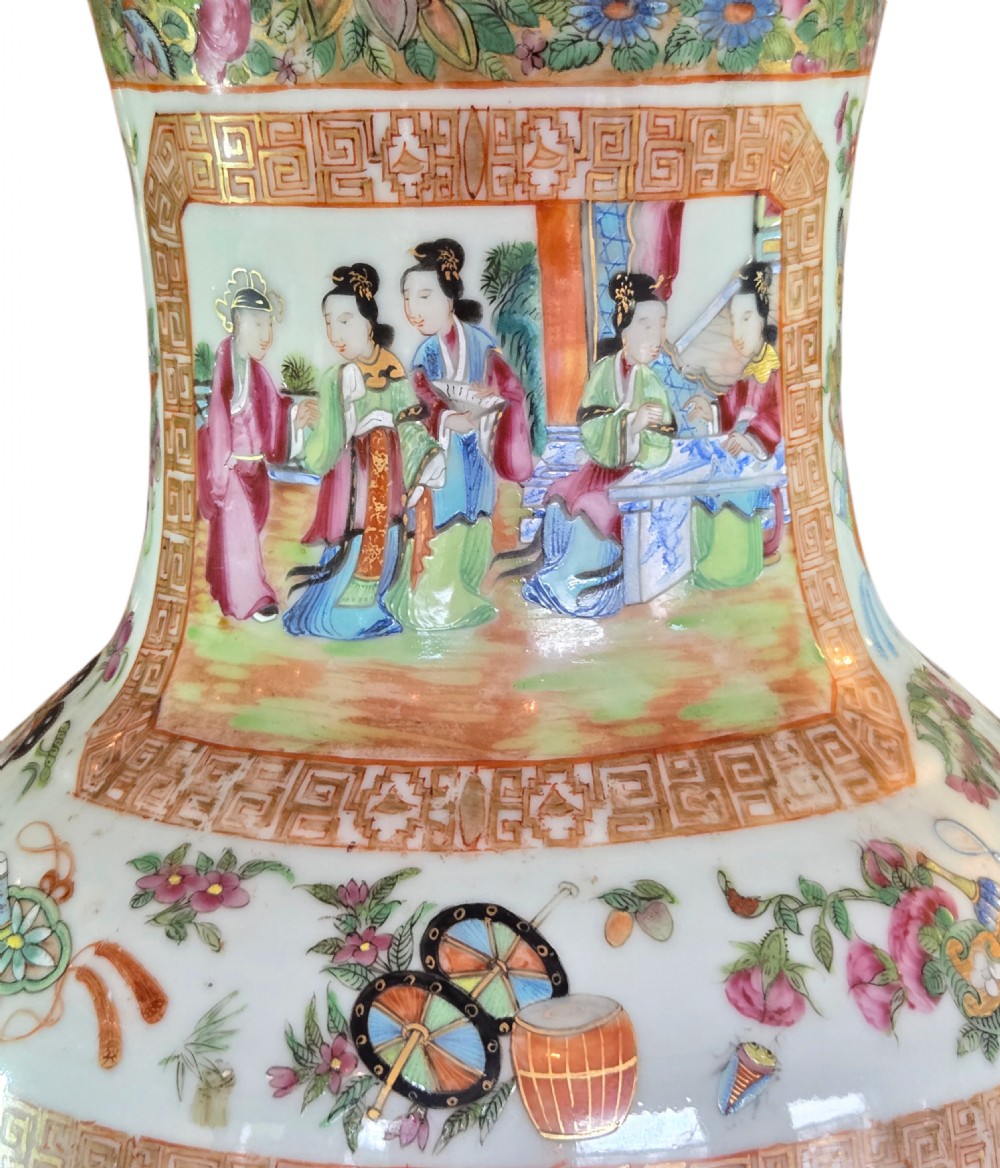 A 19th-century Cantonese Rose Mandarin porcelain baluster vase decorated with narrative figure panels, floral enamel borders, and a domed cover topped with a gilt foo dog finial. View XIV