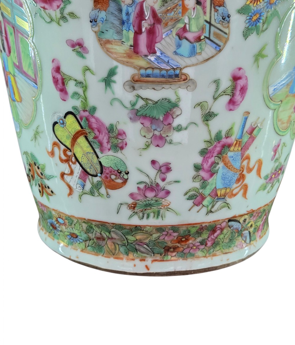 A 19th-century Cantonese Rose Mandarin porcelain baluster vase decorated with narrative figure panels, floral enamel borders, and a domed cover topped with a gilt foo dog finial. View XVI