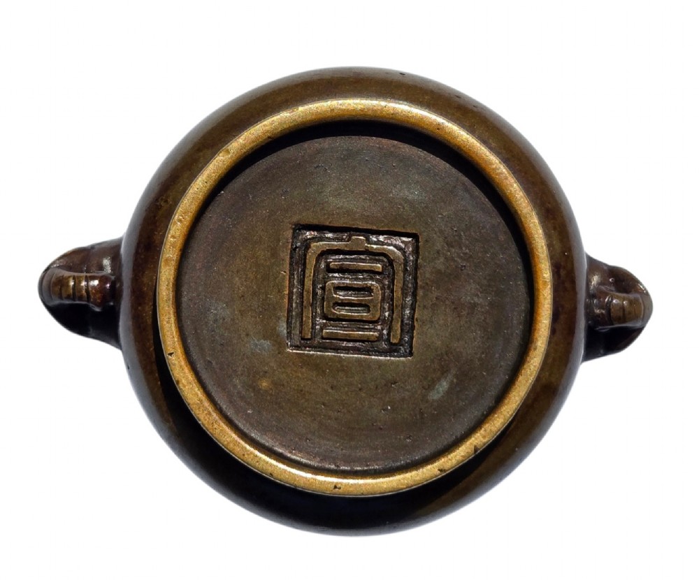 A miniature dark bronze censer featuring a rounded body, twin elephant head handles with curved trunks, and a circular raised footring. View V