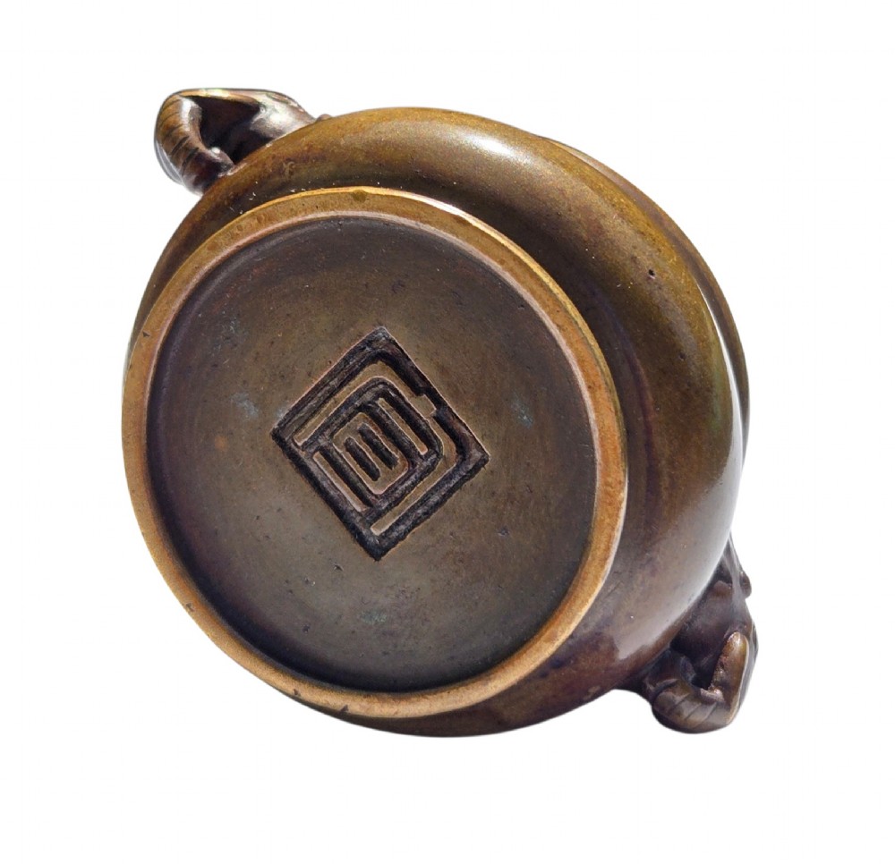 A miniature dark bronze censer featuring a rounded body, twin elephant head handles with curved trunks, and a circular raised footring. View VII