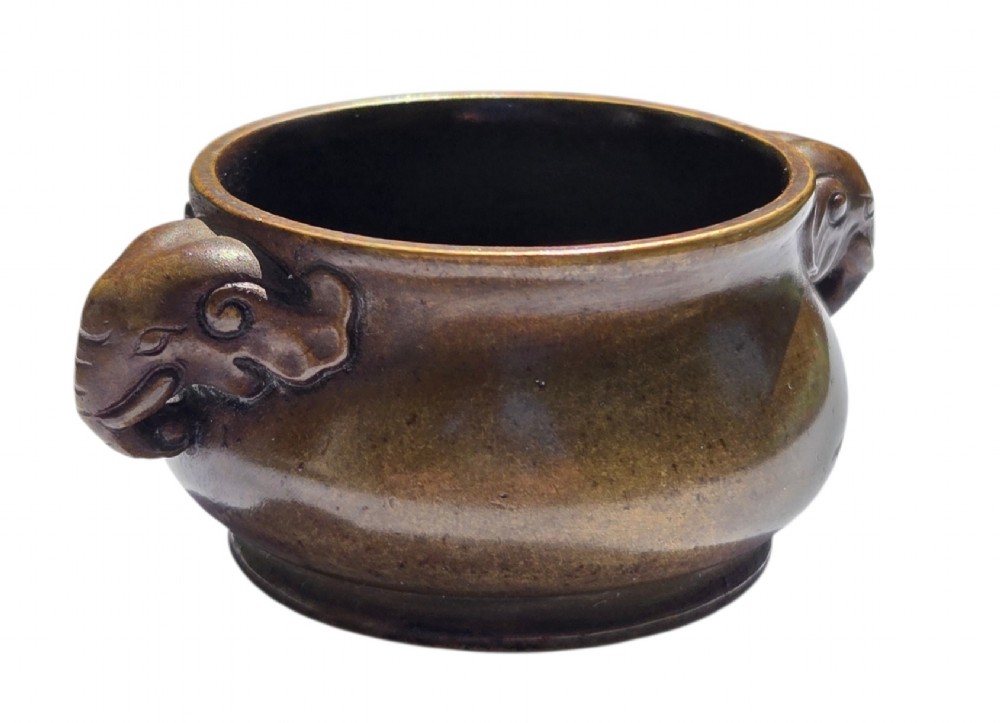 A miniature dark bronze censer featuring a rounded body, twin elephant head handles with curved trunks, and a circular raised footring. View VIII