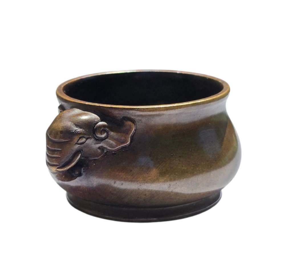 A miniature dark bronze censer featuring a rounded body, twin elephant head handles with curved trunks, and a circular raised footring. View XII