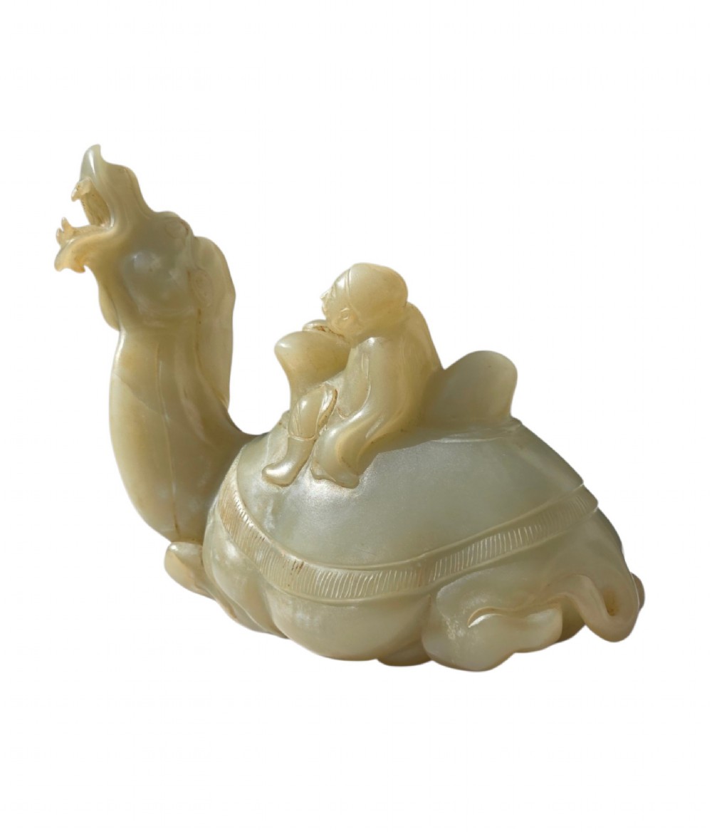 A carved pale green bowenite serpentine sculpture depicting a camel with its head raised, carrying a seated rider figure. View VII