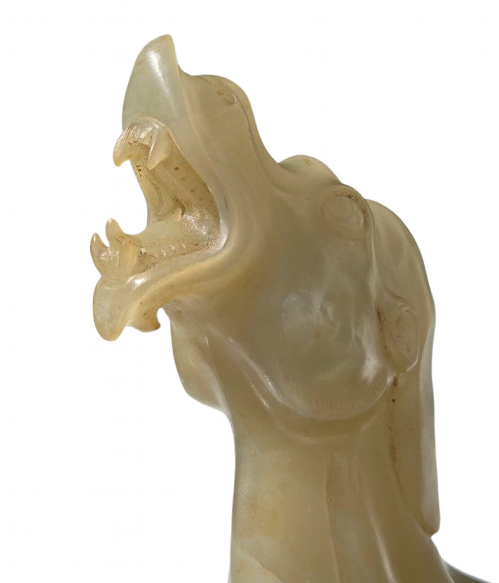 A carved pale green bowenite serpentine sculpture depicting a camel with its head raised, carrying a seated rider figure. View VIII