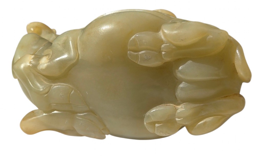 A carved pale green bowenite serpentine sculpture depicting a camel with its head raised, carrying a seated rider figure. View XI