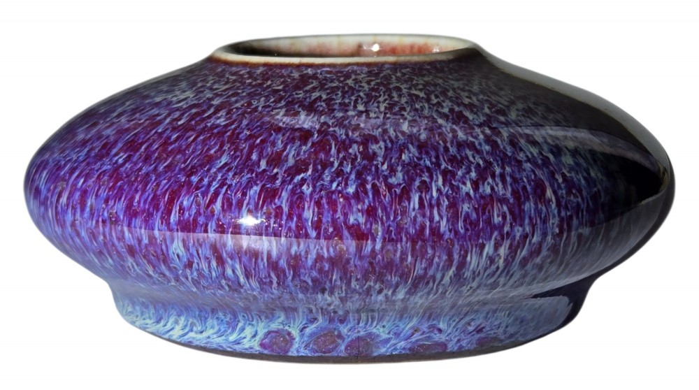 A compressed circular Chinese porcelain brush washer featuring a mottled purple and lavender blue flambe glaze. View II