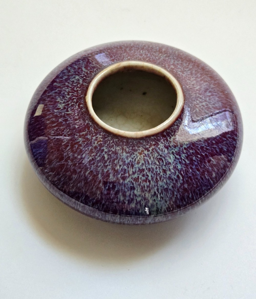 A compressed circular Chinese porcelain brush washer featuring a mottled purple and lavender blue flambe glaze. View IX