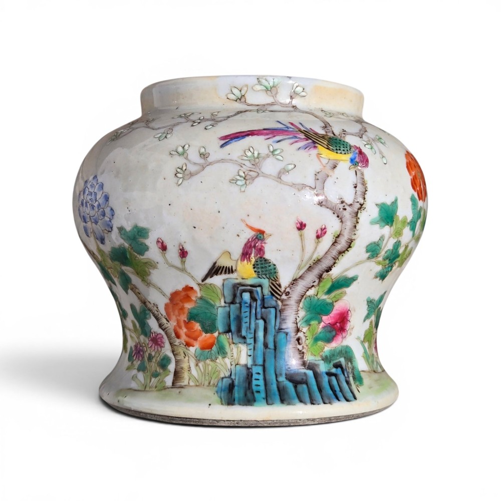 A Chinese Famille Rose porcelain jar decorated with hand-painted birds, flowers, and rockwork against a white ground.