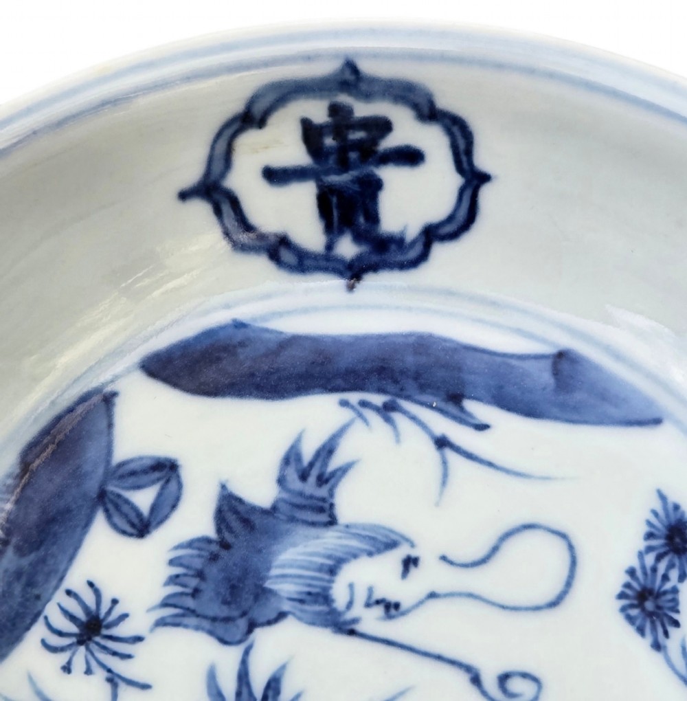 A circular Chinese blue and white porcelain deep saucer dish decorated with cobalt underglaze imagery of Shoulao, a crane, and character cartouches. View II