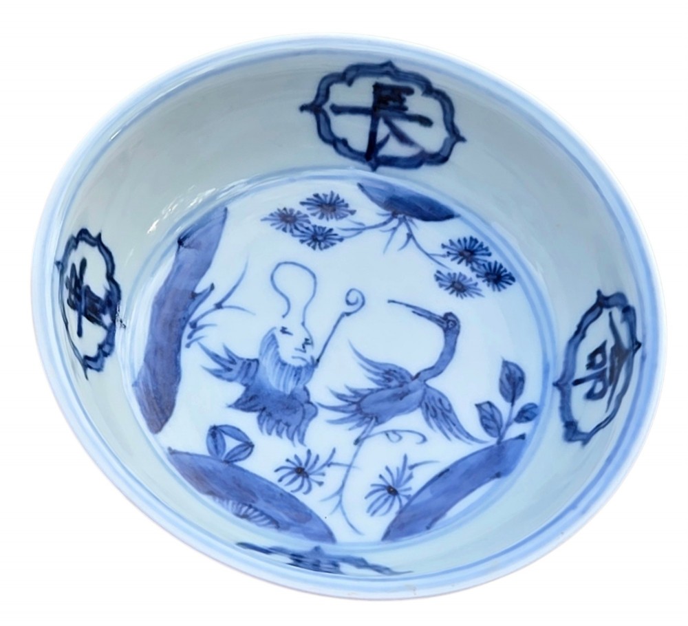 A circular Chinese blue and white porcelain deep saucer dish decorated with cobalt underglaze imagery of Shoulao, a crane, and character cartouches. View XI
