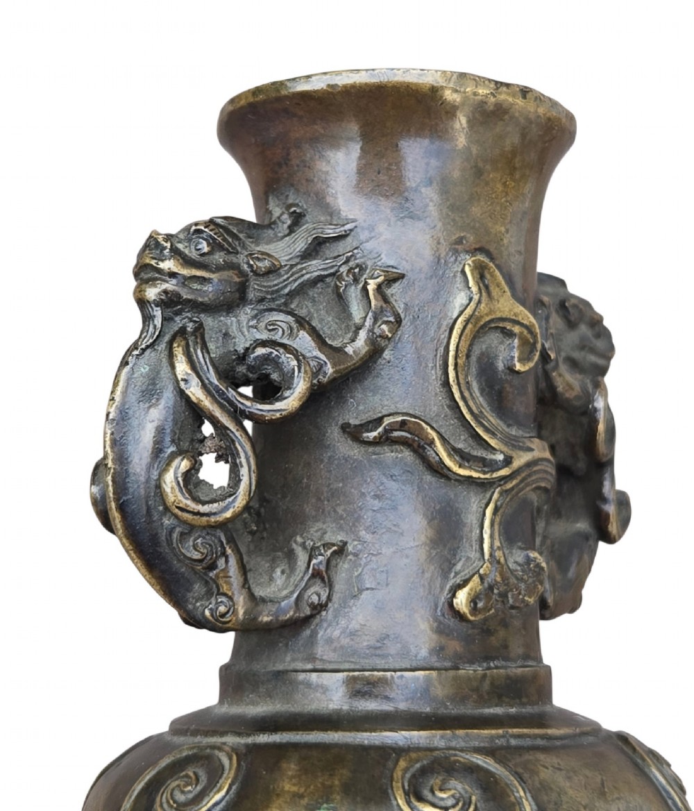 A patinated cast bronze Chinese vase featuring stylised dragon-head handles and raised Yingluo beaded tassels. View X