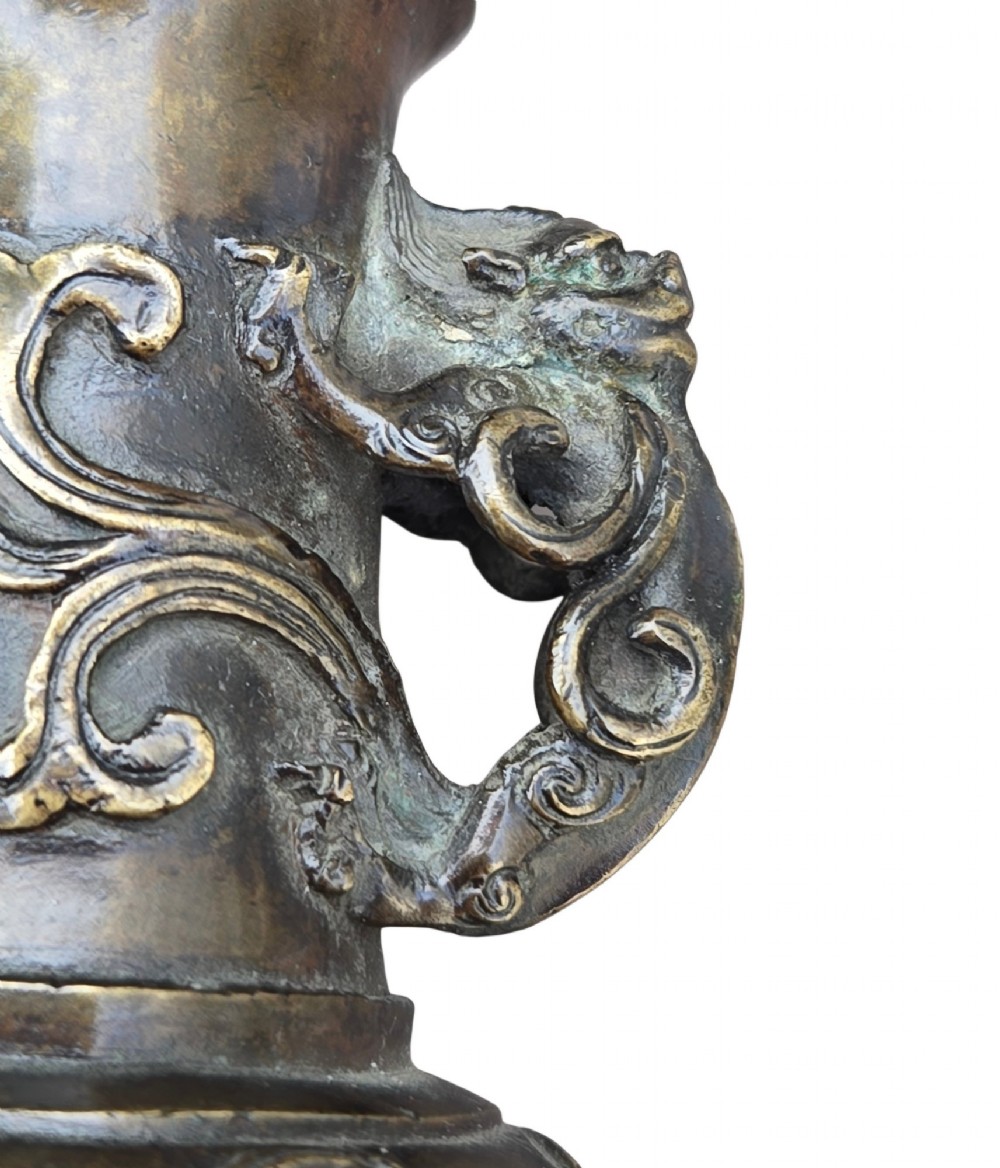 A patinated cast bronze Chinese vase featuring stylised dragon-head handles and raised Yingluo beaded tassels. View XV