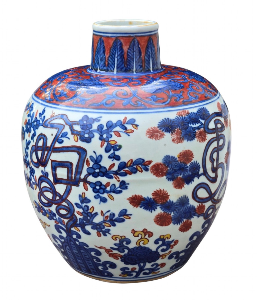 An antique Chinese porcelain jar decorated with underglaze blue and iron-red motifs, featuring plantain leaves and a central longevity symbol. View II