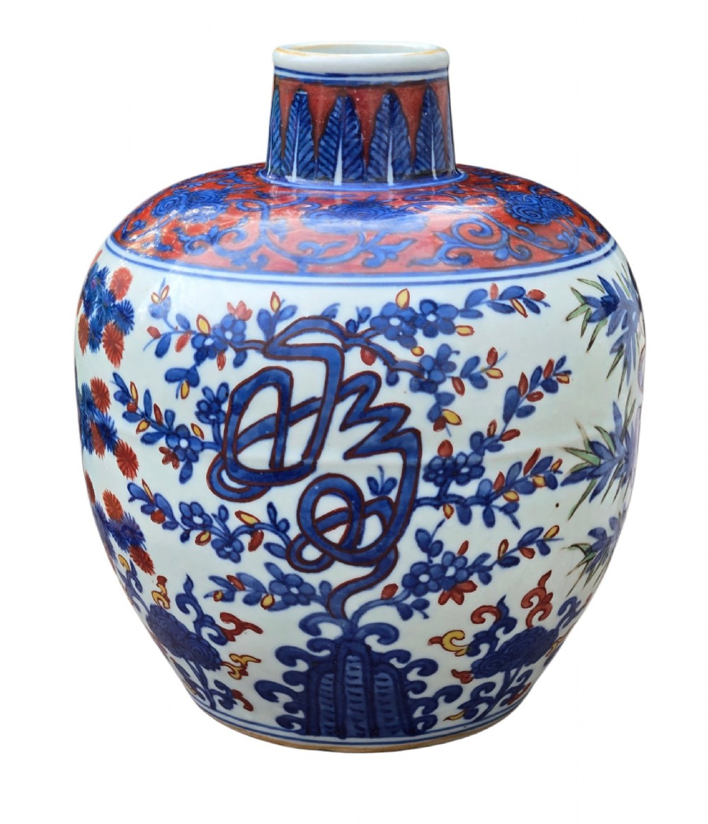 An antique Chinese porcelain jar decorated with underglaze blue and iron-red motifs, featuring plantain leaves and a central longevity symbol. View V