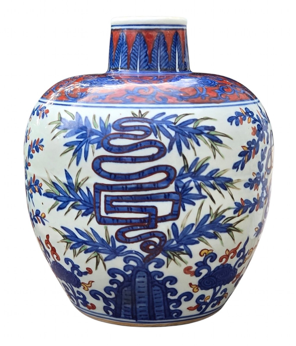 An antique Chinese porcelain jar decorated with underglaze blue and iron-red motifs, featuring plantain leaves and a central longevity symbol. View VII