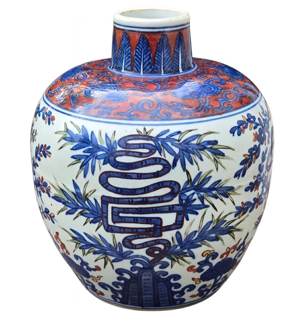 An antique Chinese porcelain jar decorated with underglaze blue and iron-red motifs, featuring plantain leaves and a central longevity symbol. View X