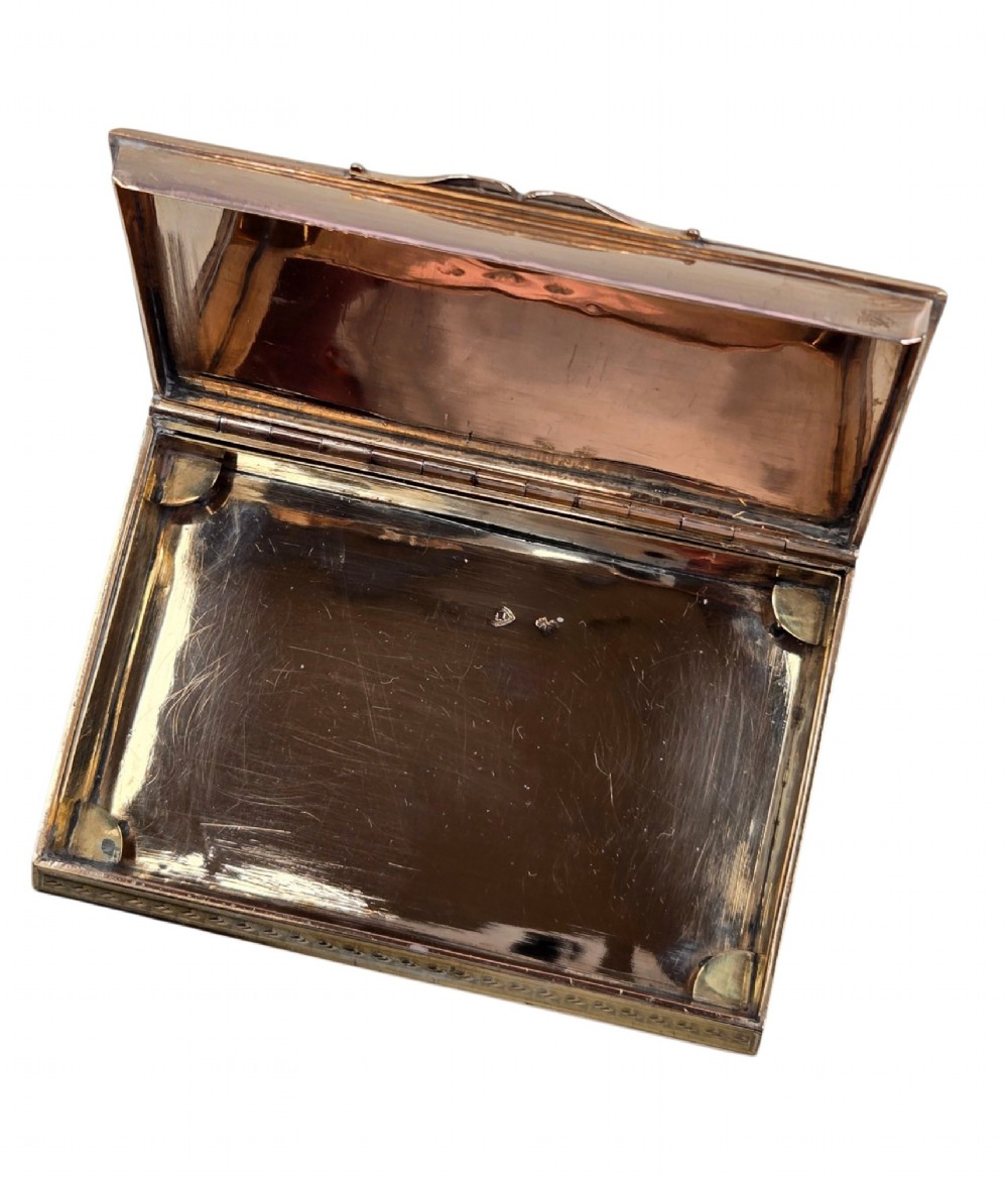 A rectangular 18K gold snuff box featuring engine-turned panels and chased floral relief borders in multi-toned gold. View V