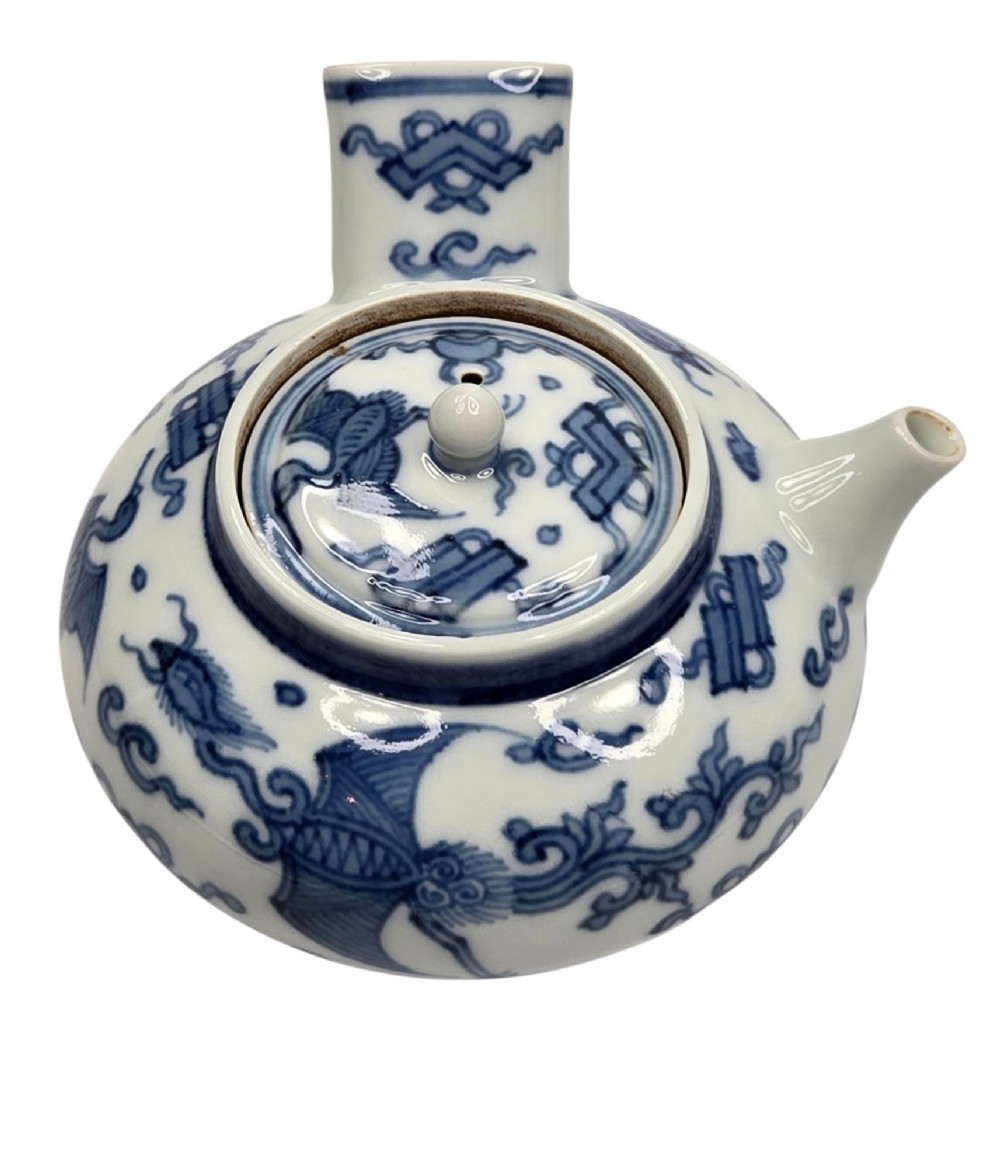A Japanese porcelain side-handled teapot featuring hand-painted cobalt blue motifs against a white background.
