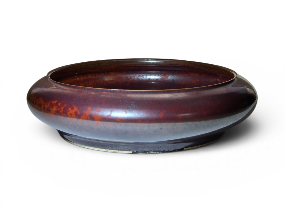 A low compressed circular ceramic brush washer featuring a dark reddish-brown iron rust glaze with subtle metallic speckling.
