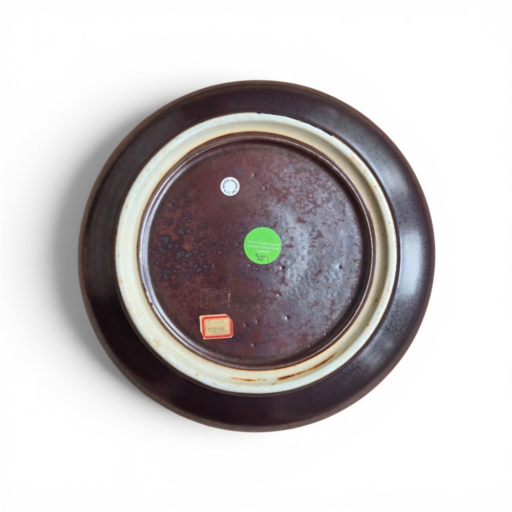 A low compressed circular ceramic brush washer featuring a dark reddish-brown iron rust glaze with subtle metallic speckling. View II