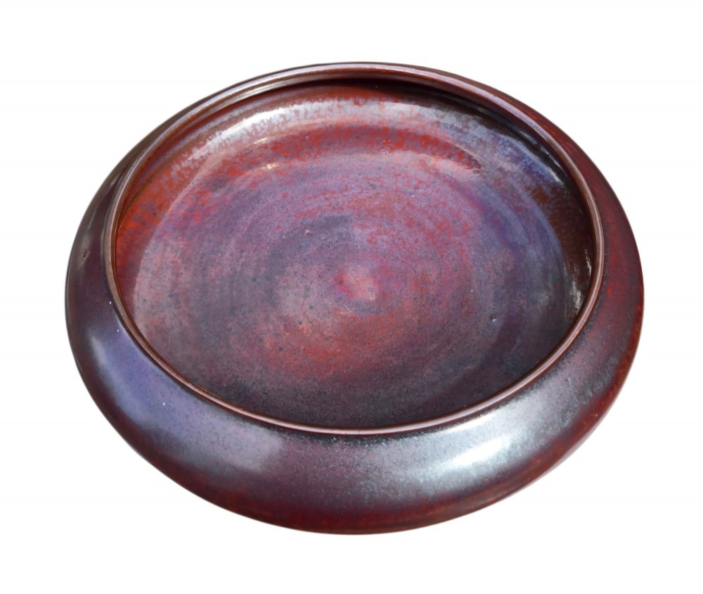 A low compressed circular ceramic brush washer featuring a dark reddish-brown iron rust glaze with subtle metallic speckling. View VI