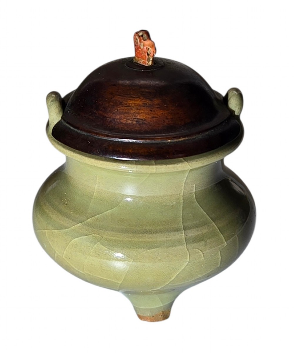 A miniature pale celadon green tripod censer with a distinct crackle glaze, fitted with a dark wood cover and a carved red coral finial. View II