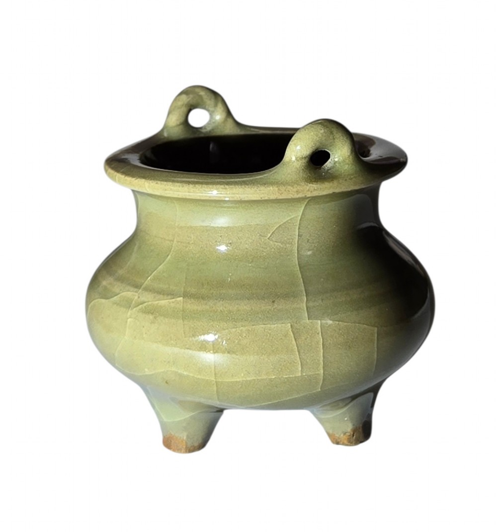 A miniature pale celadon green tripod censer with a distinct crackle glaze, fitted with a dark wood cover and a carved red coral finial. View VI