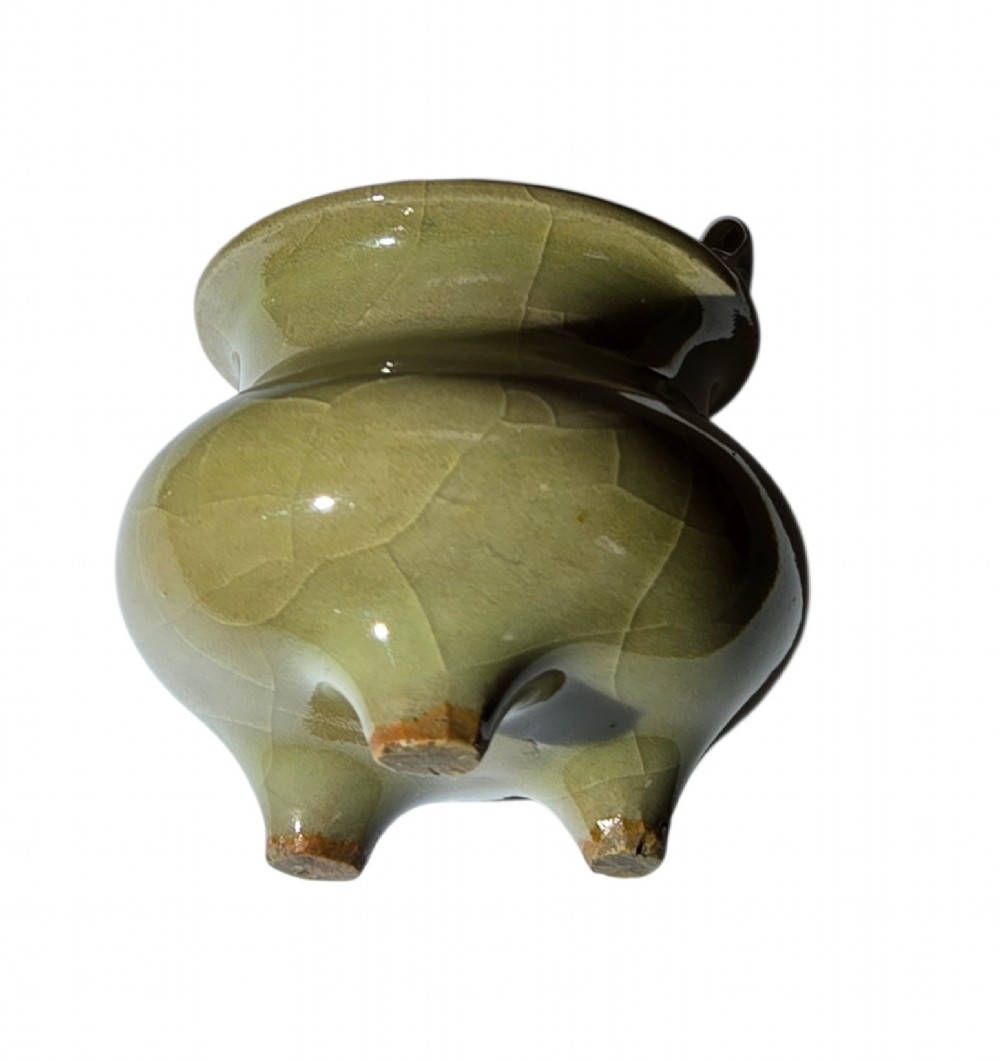 A miniature pale celadon green tripod censer with a distinct crackle glaze, fitted with a dark wood cover and a carved red coral finial. View VIII
