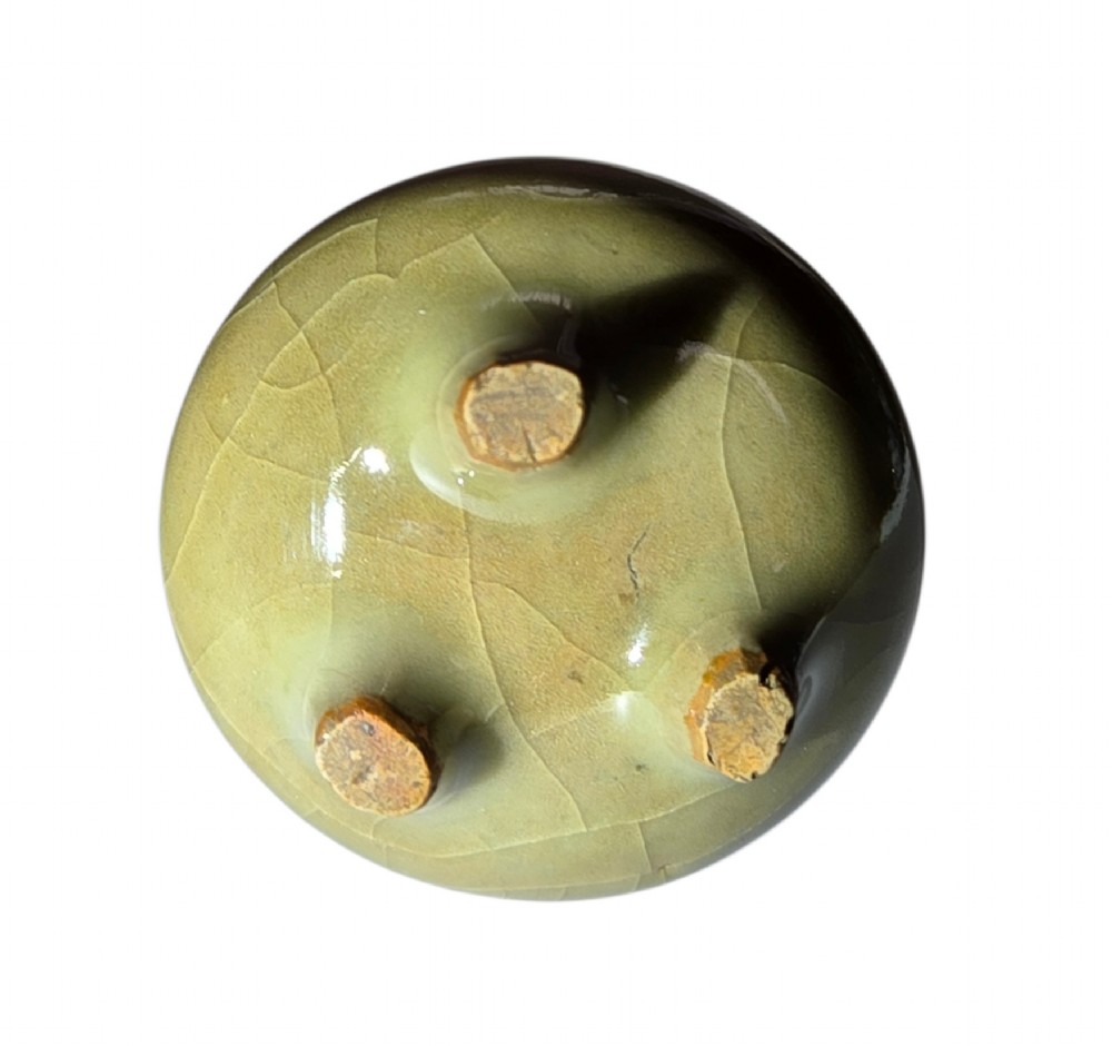 A miniature pale celadon green tripod censer with a distinct crackle glaze, fitted with a dark wood cover and a carved red coral finial. View XI