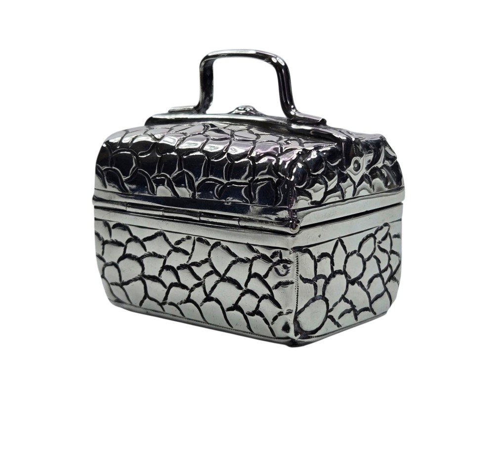 A late Victorian sterling silver novelty box crafted in the form of a miniature trunk with embossed crocodile skin texture and a top carrying handle. View III
