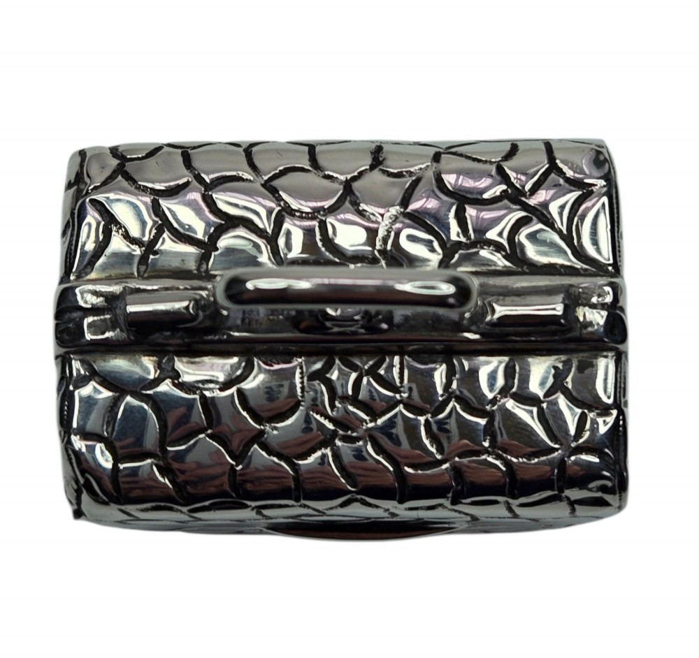 A late Victorian sterling silver novelty box crafted in the form of a miniature trunk with embossed crocodile skin texture and a top carrying handle. View IV