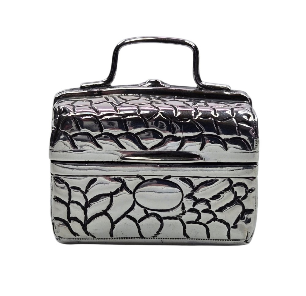 A late Victorian sterling silver novelty box crafted in the form of a miniature trunk with embossed crocodile skin texture and a top carrying handle. View VI